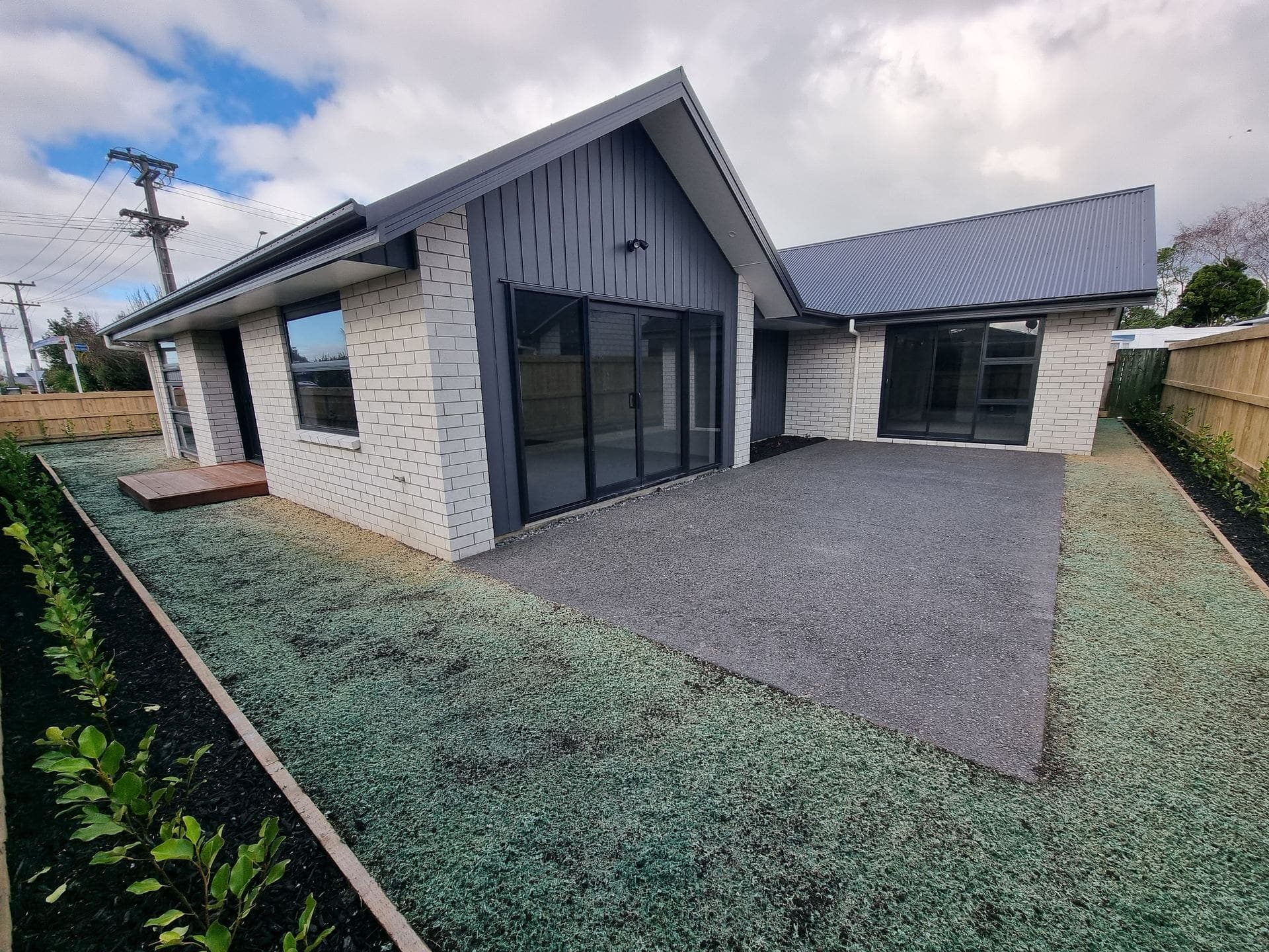 A freshly hydroseeded lawn at a new-build home in Hamilton, still showing the green-tinged spray coating before germination
