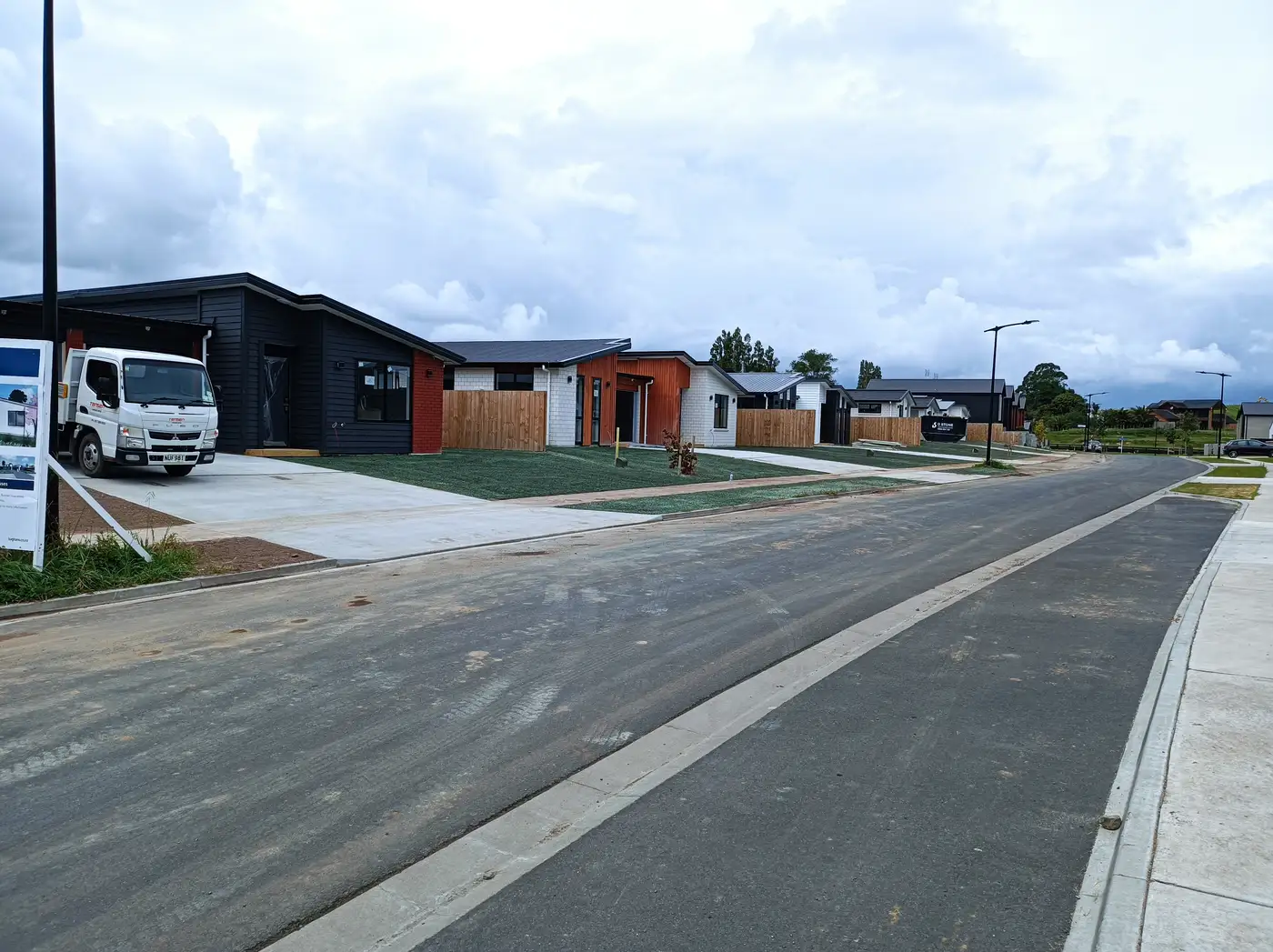 A finished exposed aggregate driveway in Hamilton, crossing meeting the road cleanly at the correct width
