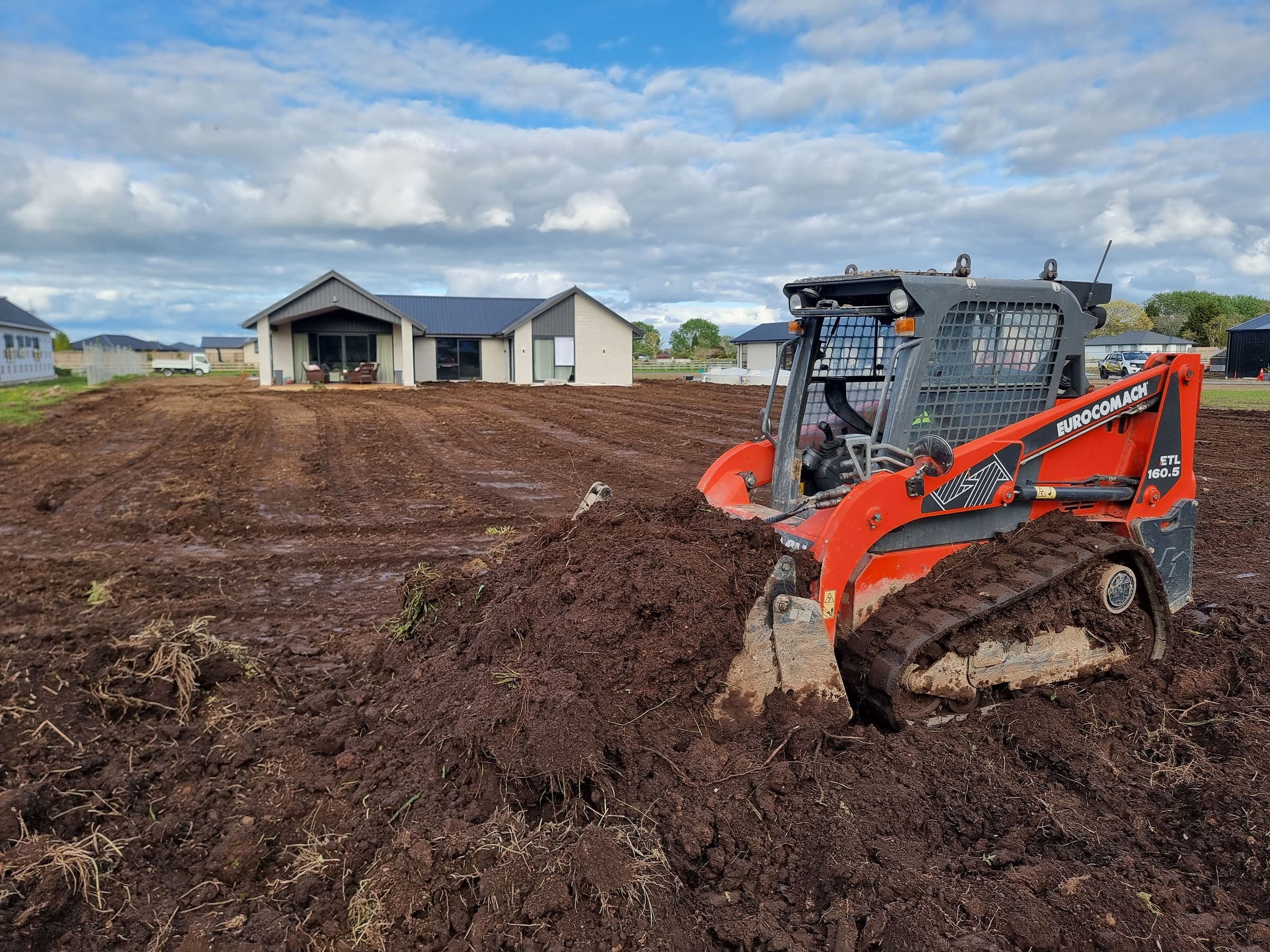 Skid steer levelling the section in front of a new Hamilton build