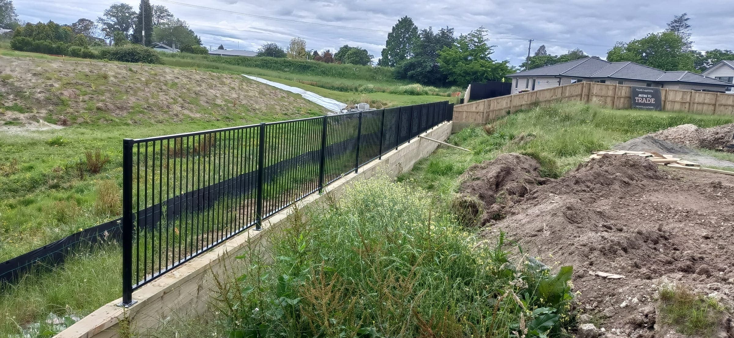 Aluminium fencing on top of a retaining wall