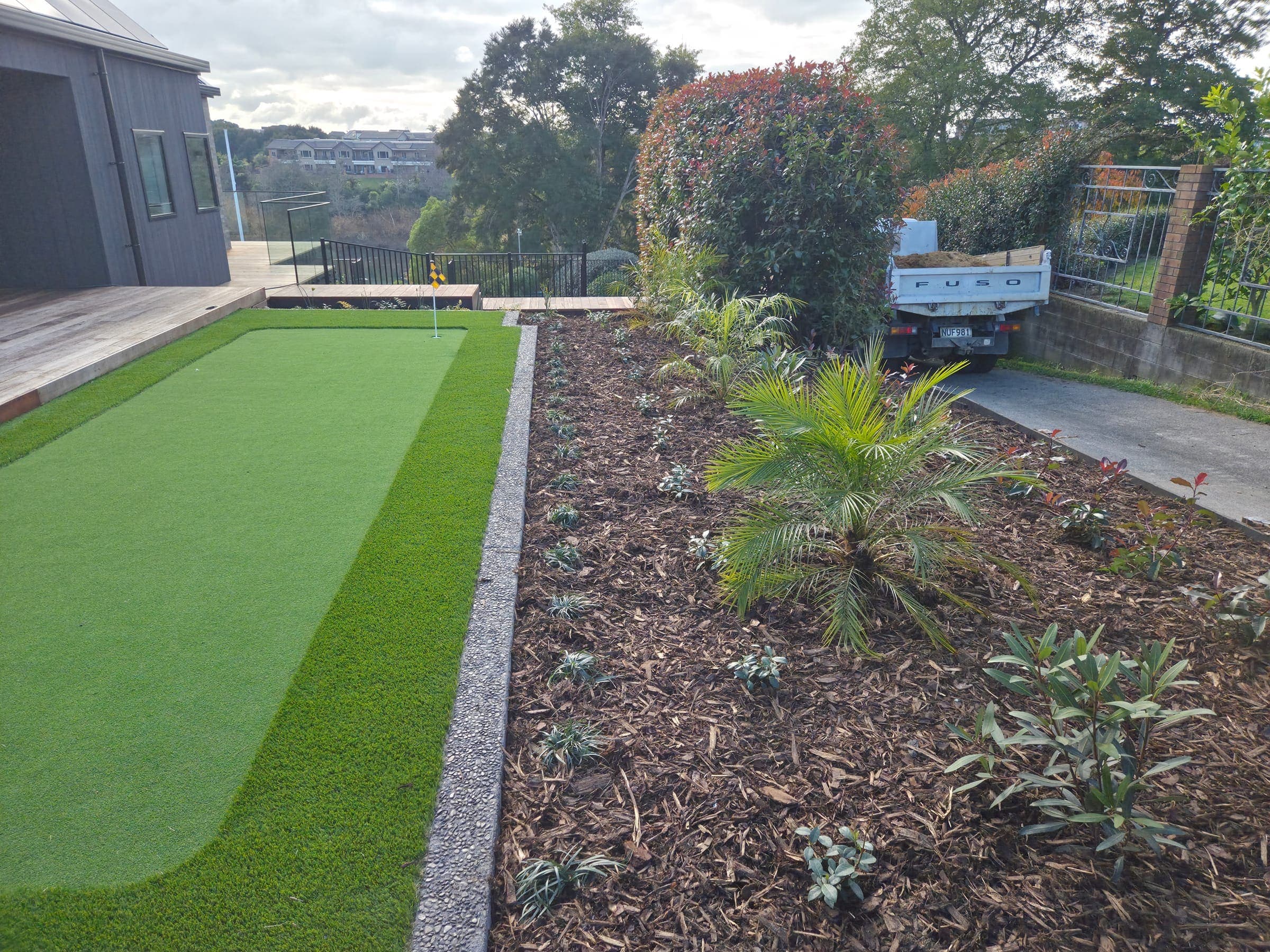 Garden bed bordering a backyard putting green